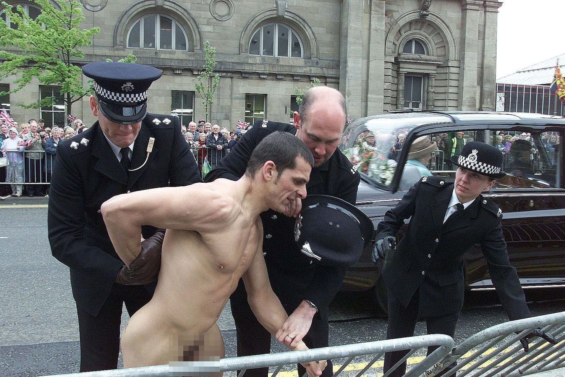 Полиция задерживает голого мужчина возле собора Святой Марии, когда  Елизавета II проезжает мимо, 2002 год