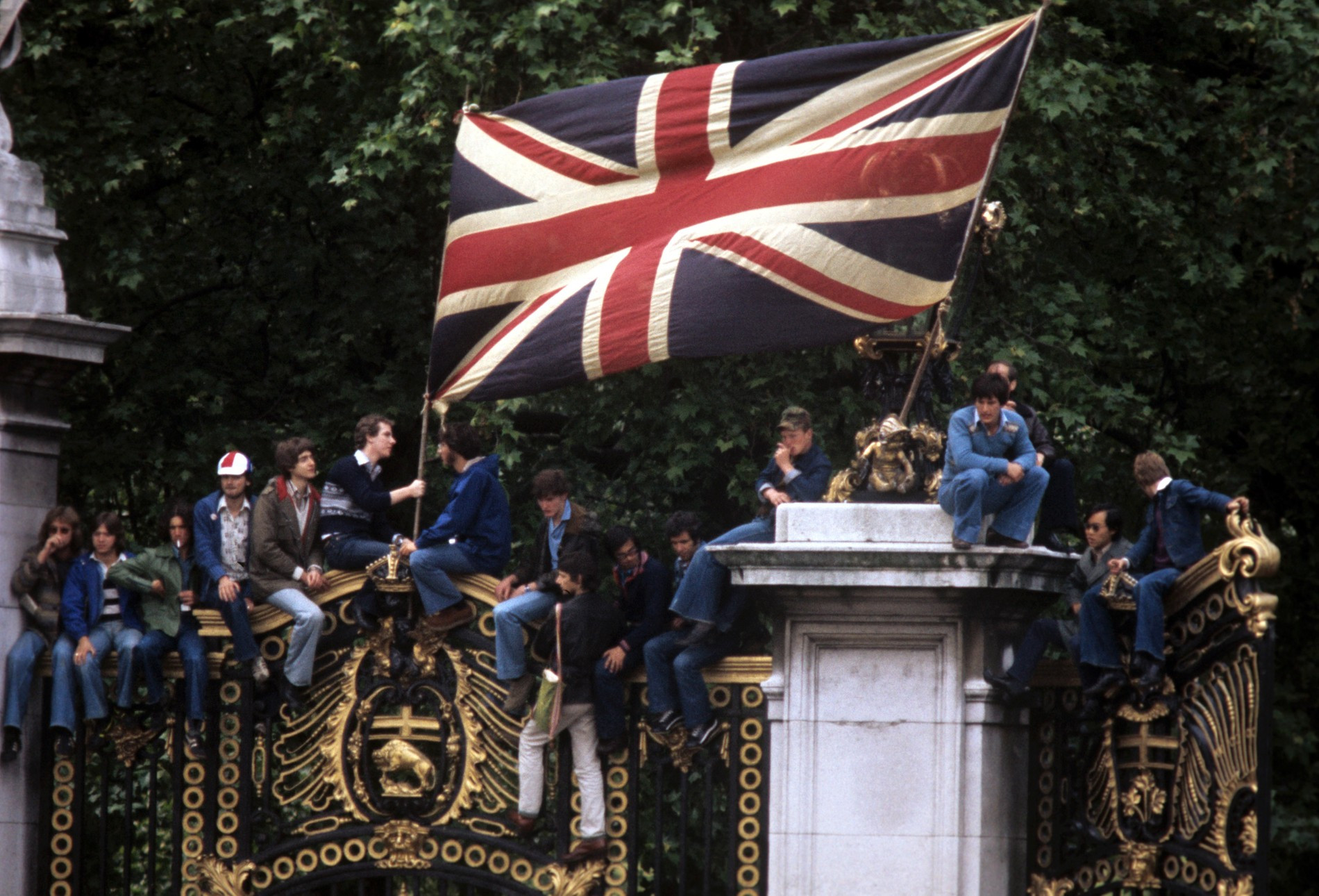 Жители Лондона забрались на забор Букингемского дворца, чтобы лучше видеть королевскую процессию, 1977 год
