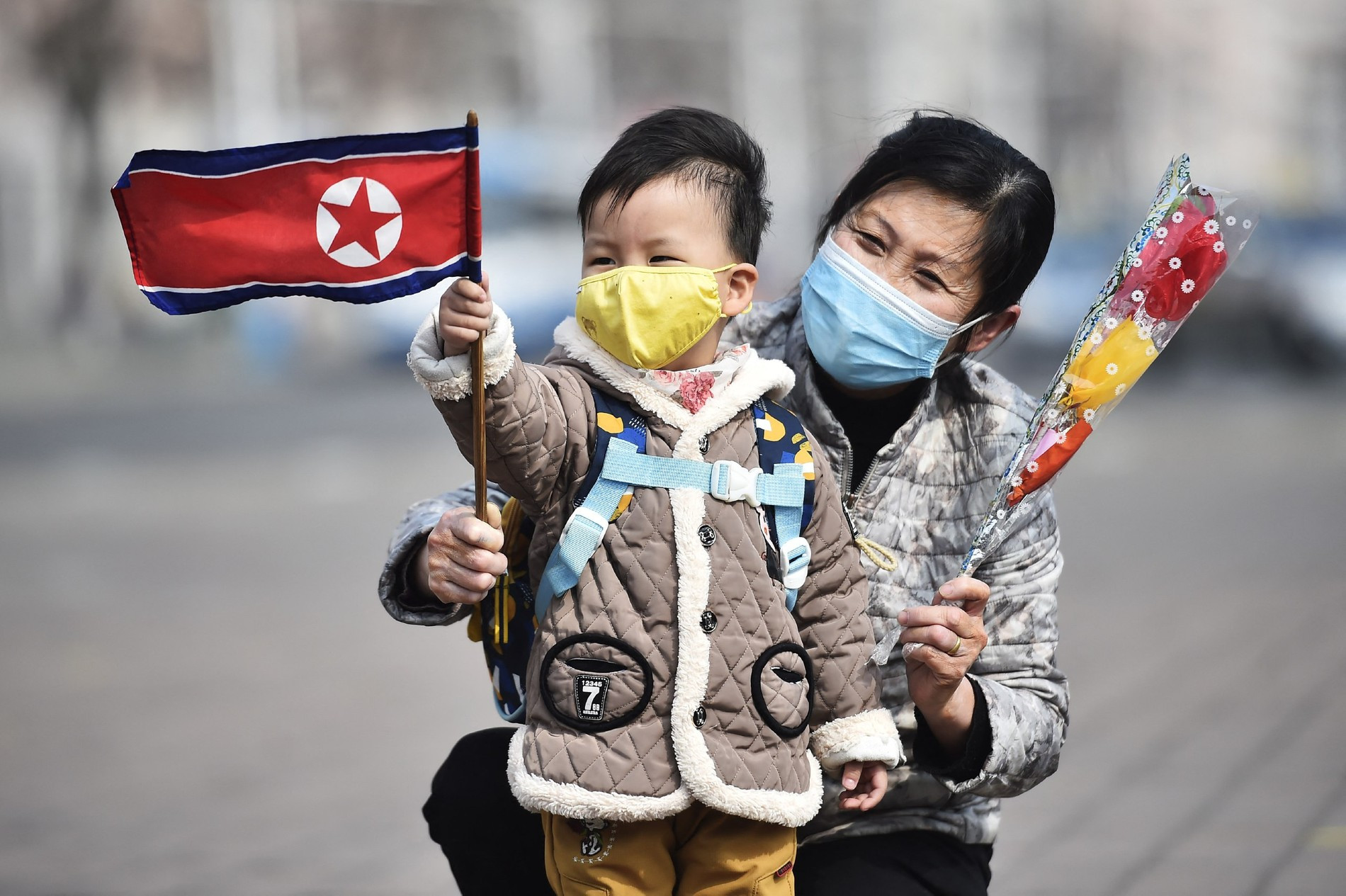 Мать и ребенок с национальным флагом в Пхеньяне
Фото: Getty Images