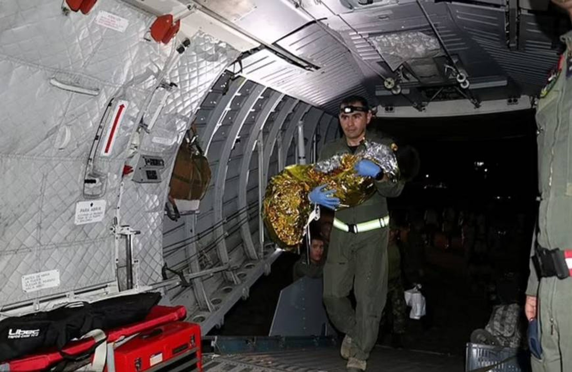 Спасатель заносит ребенка на борт самолета 
Фото: Daily Maill