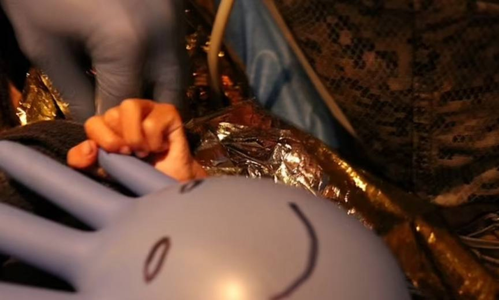 Один из детей с медицинской перчаткой, на которой спасатель нарисовал забавную рожицу
Фото: Daily Mail