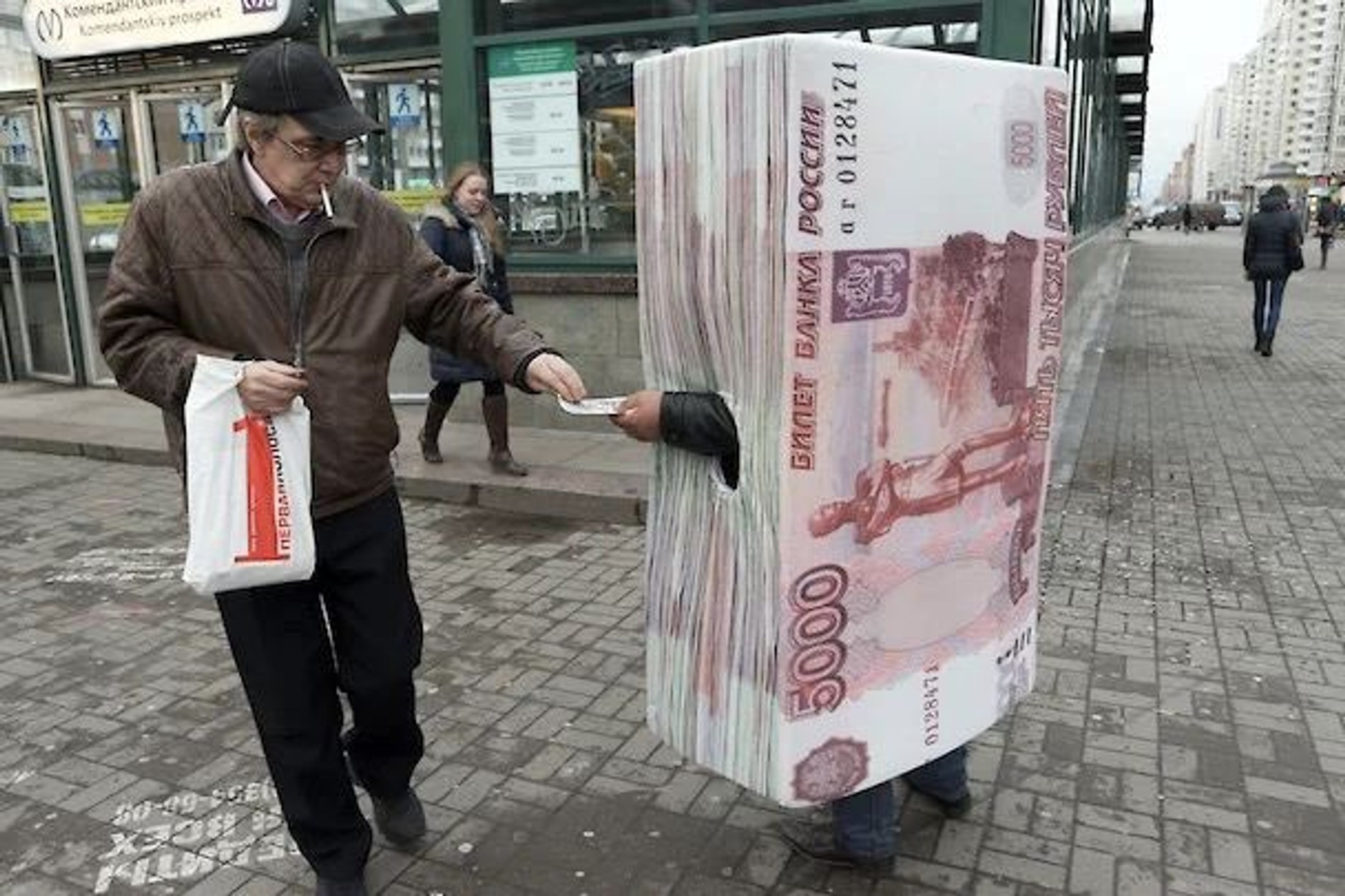 Человек в костюме пятитысячной купюры раздает листовки кредитной организации. Источник: Интерпресс / PhotoXPress.ru