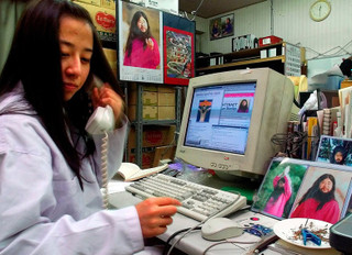 Последовательница «Аум Синрике» в офисе, украшенном фото Секо Асахары. Источник: соцсети